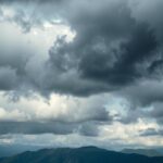 A darkened landscape with storm clouds and distant mountains, representing political tension and conflict in Ethiopia.