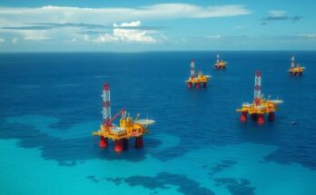 Oil and gas fields with offshore platforms and calm waters under a blue sky in Trinidad and Tobago.