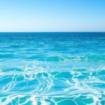 A serene seaside view of a calm ocean under a clear blue sky, reflecting tranquility and hope for a peaceful future.